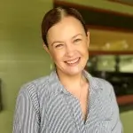 Courtney Politano smiling in front of a green house