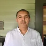 Headshot of Carlos Zuniga against Institute for Educational Advancement's green house exterior