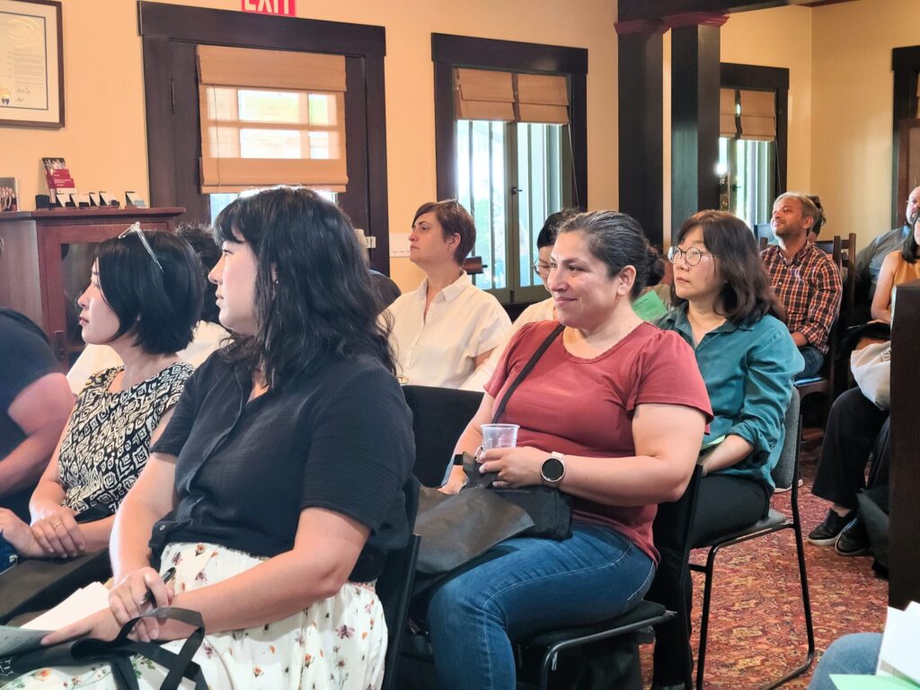 Parents sitting in rows in a living area, smiling during a presentation